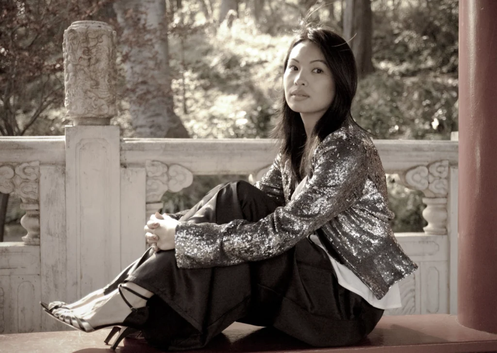 Femme en veste à sequins assise sous un pavillon