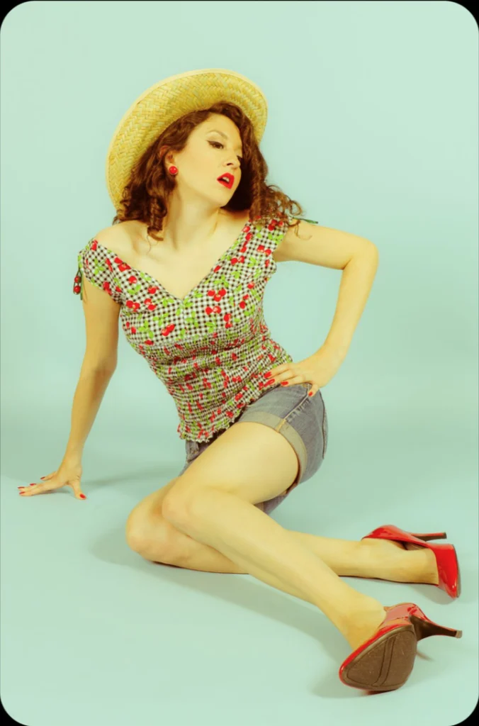 Pin-up en chapeau de paille et escarpins rouges, sur fond vert d'eau