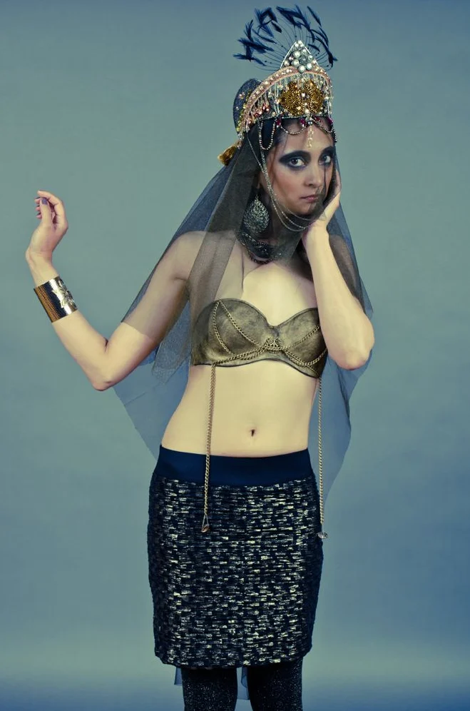 Femme en tenue de danseuse orientale, voile et coiffe dorée, sur fond bleu