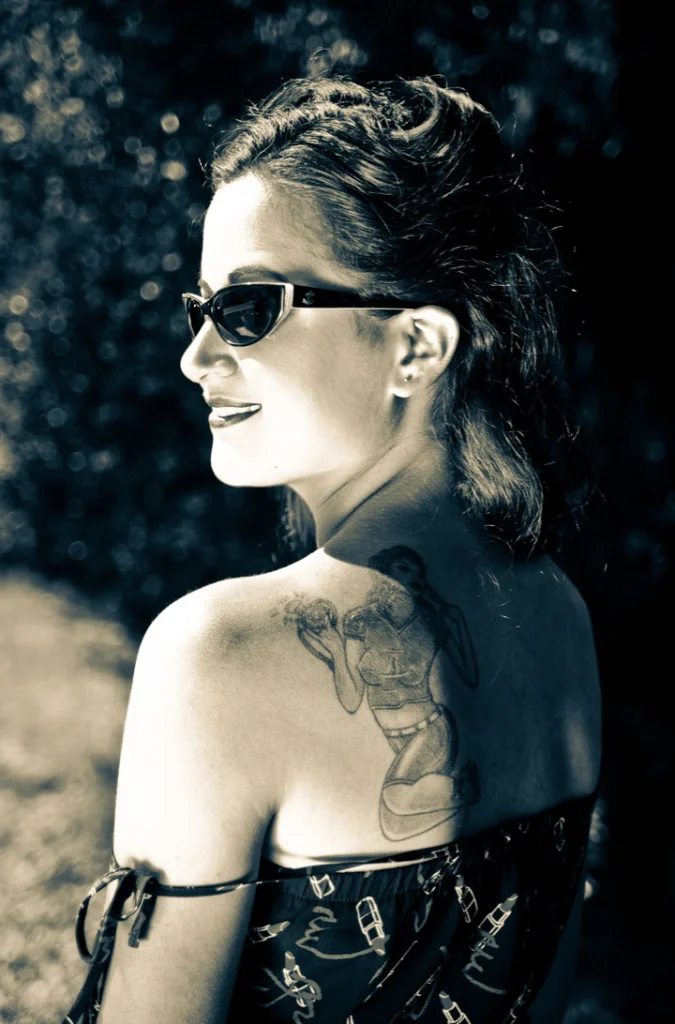 Femme de dos en lunettes de soleil, épaule tatouée