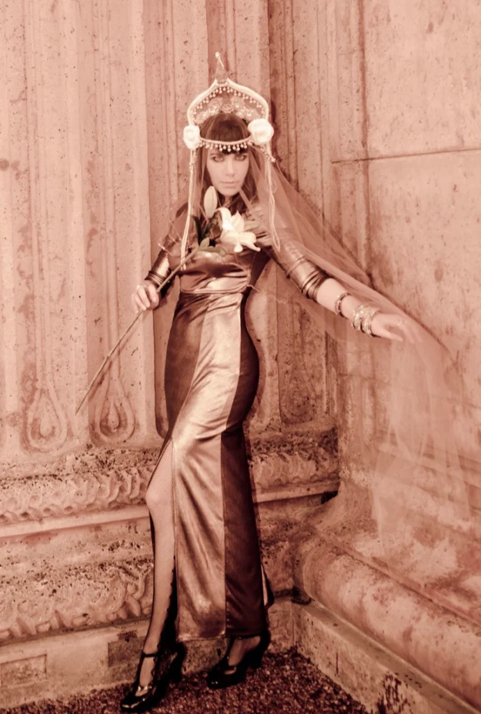 Femme en robe dorée et coiffe ornée dans un décor sculpté