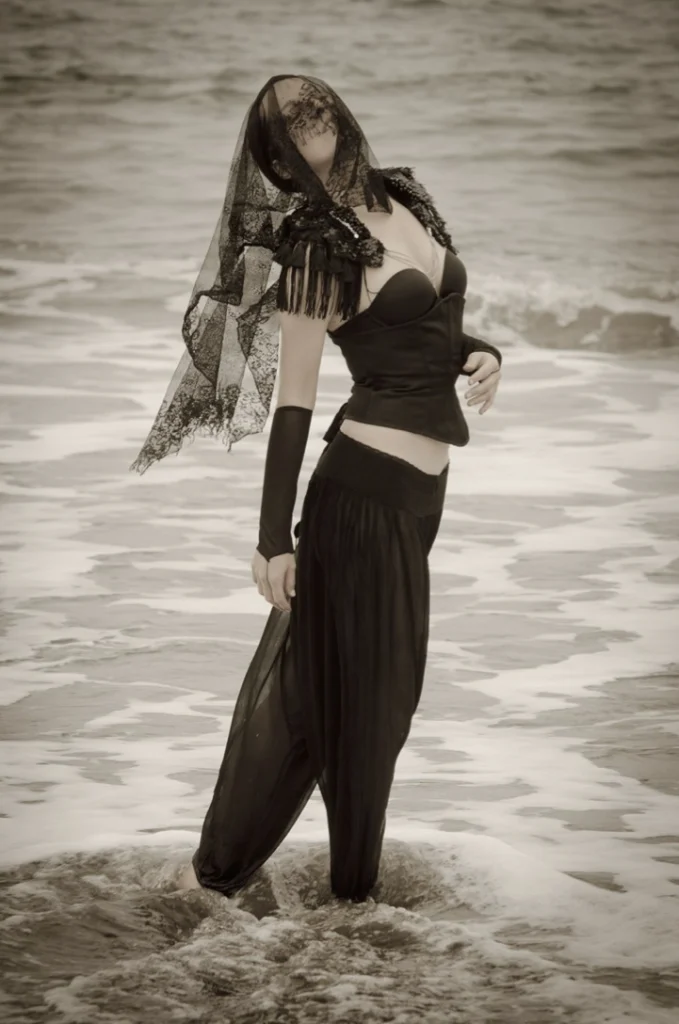 Femme voilée debout dans les vagues, en noir et blanc