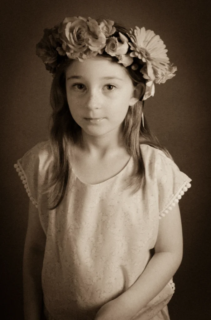 Fillette couronnée de fleurs, en blouse claire