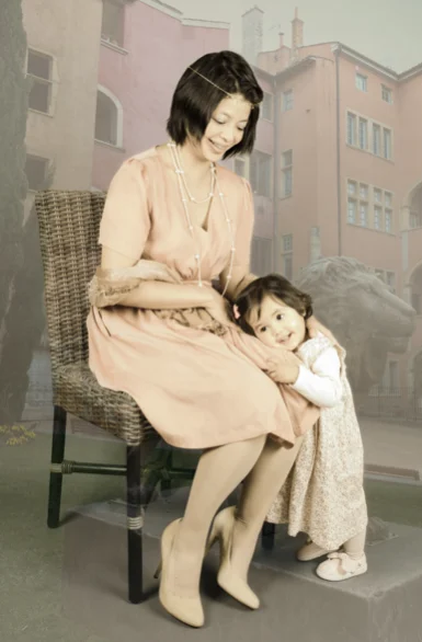 Mère et sa fille sur une chaise devant un décor de façades