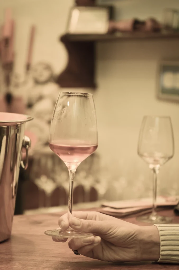 Main tenant un verre de vin rosé