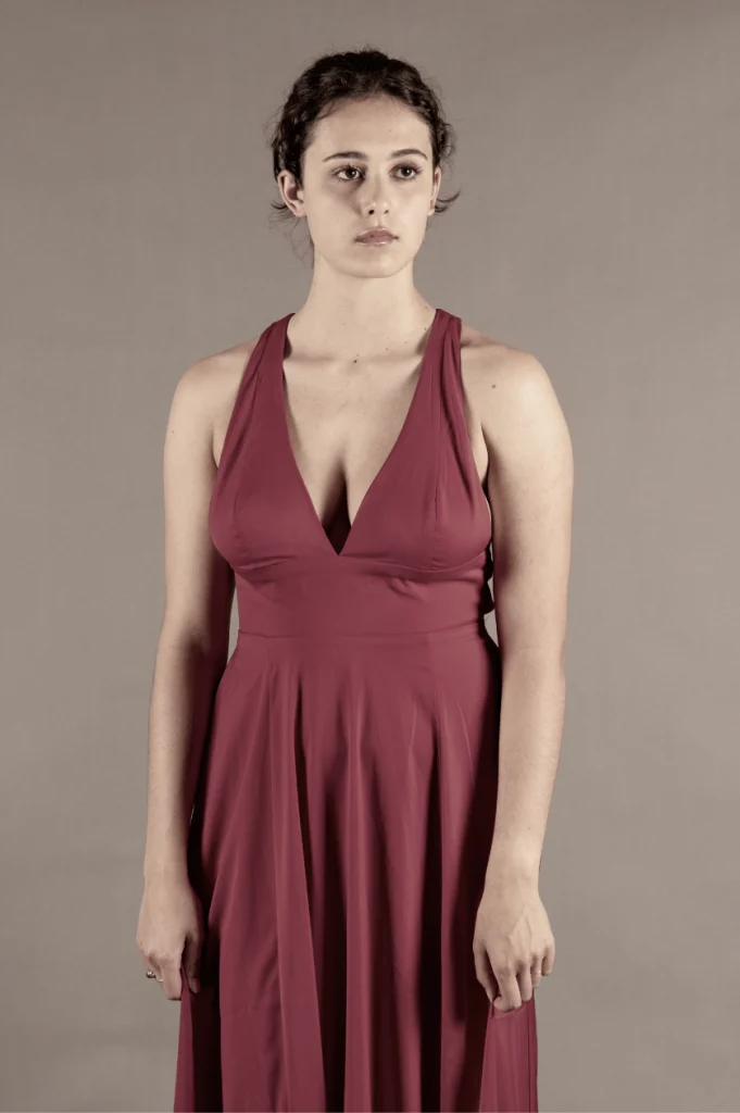 Jeune femme debout en robe longue bordeaux