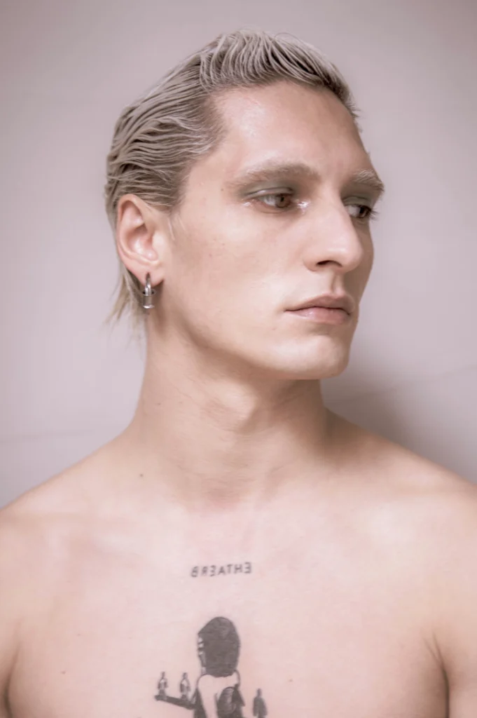 Portrait d'un jeune homme de profil, torse tatoué